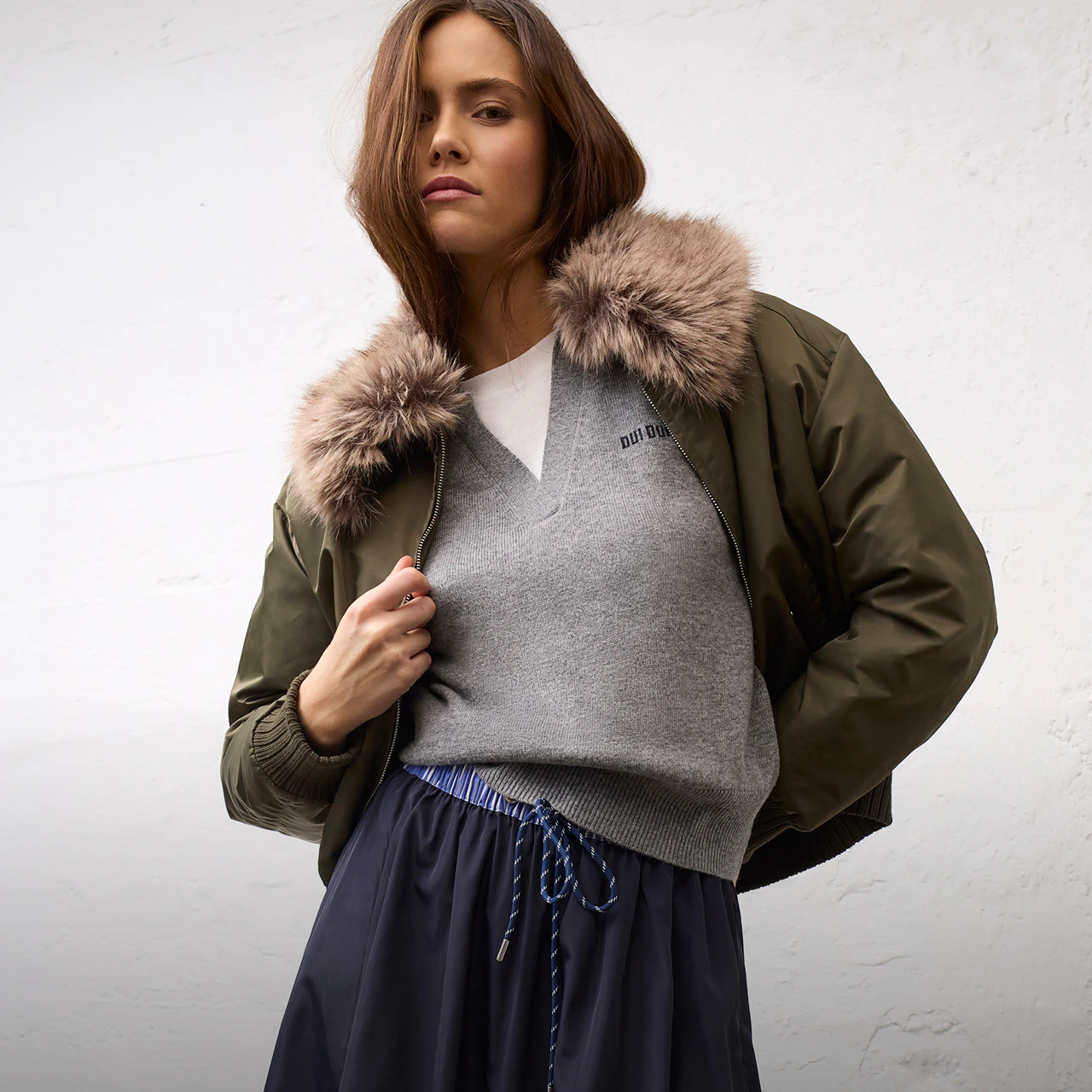 Women’s fashion from Oui, featuring a knitted jumper and a jacket with a fur collar from the current collection.