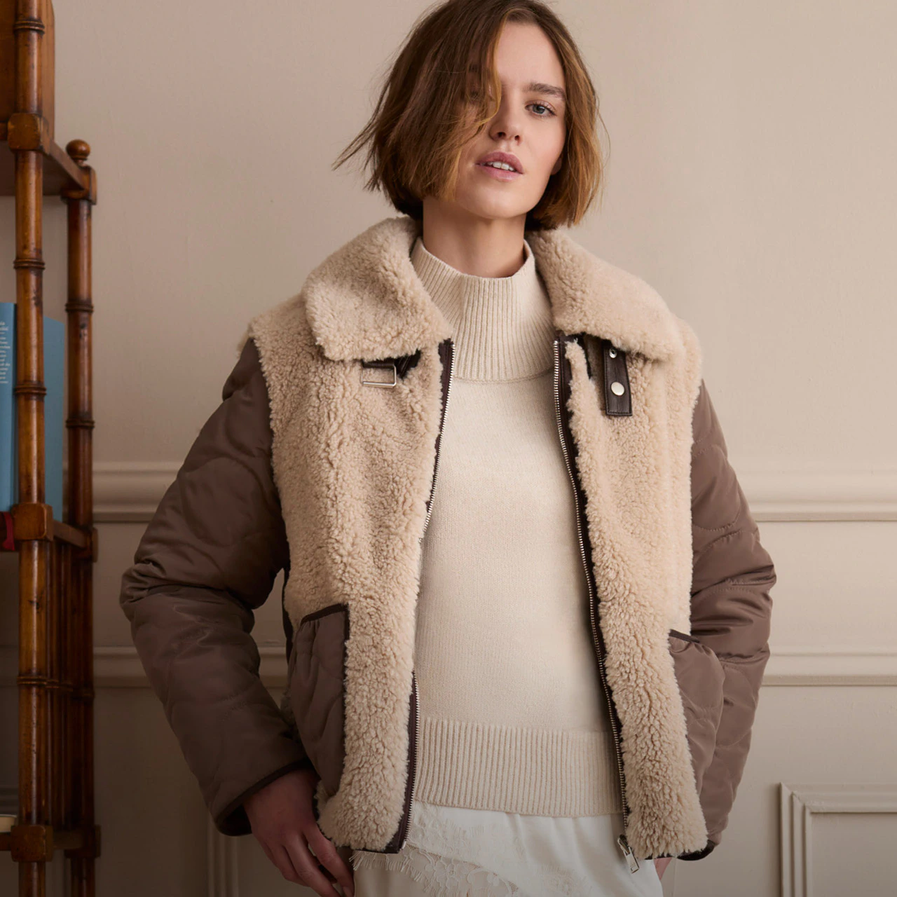 Model wearing a beige jumper and a brown jacket with teddy fur.