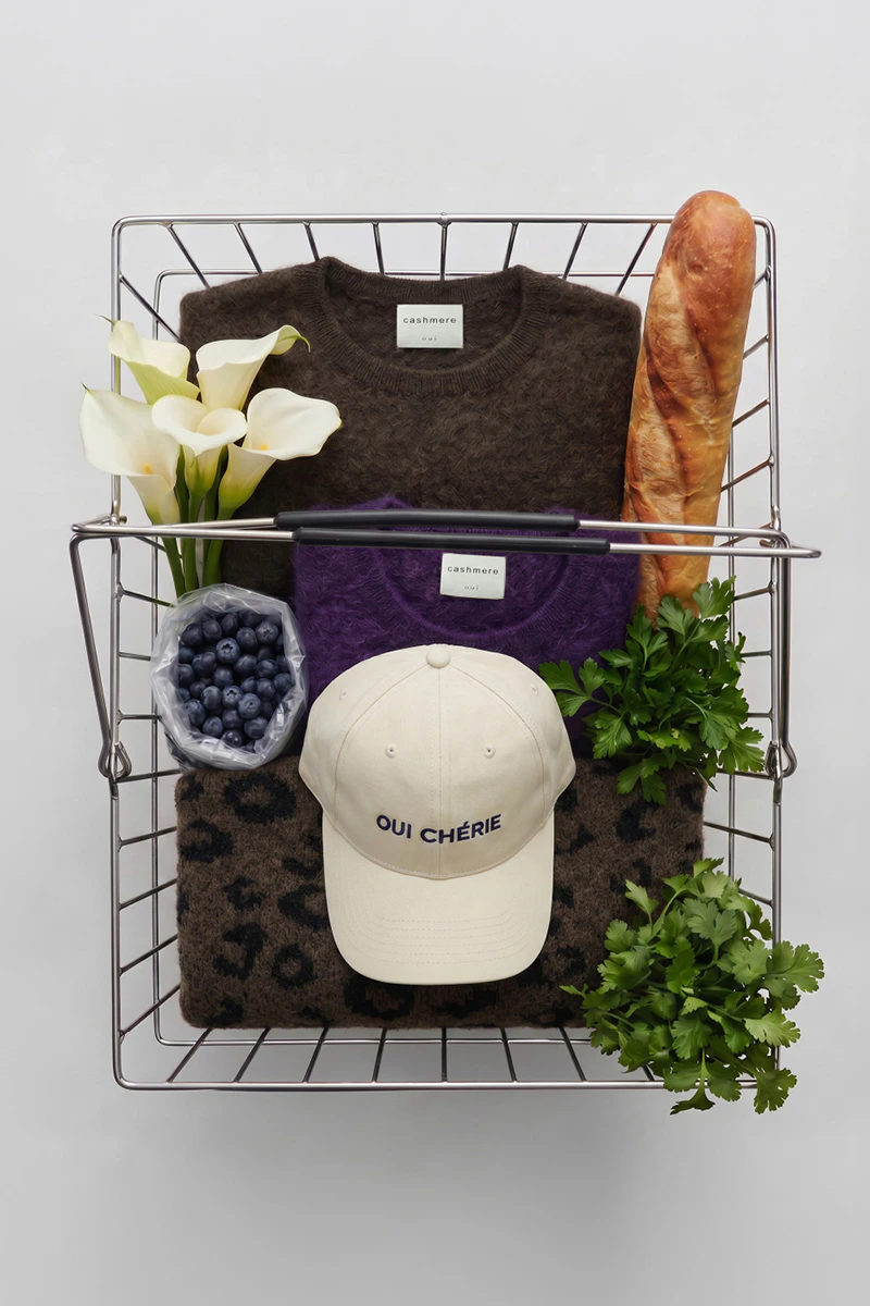 Cashmere jumpers, knitted jumpers and a cap from Oui, presented in an inspiring way in the shopping basket.