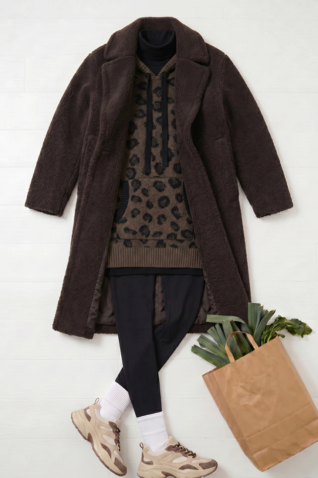 Moodbild von Oui mit Teddy-Mantel, Strickhoodie, Hose und Sneakern im Casual-Look.