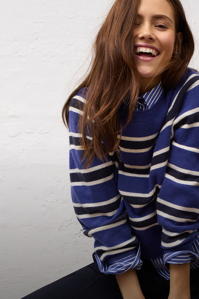 Women’s fashion from Oui, featuring a blue, white and black striped jumper and blouse from the current collection