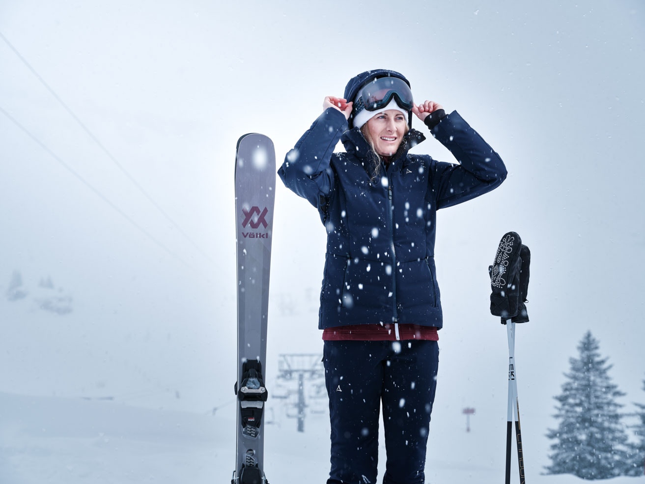 Skifahren lernen; eine Skifahrerin zieht im Schneefall ihre Kapuze über den Kopf; Schöffel