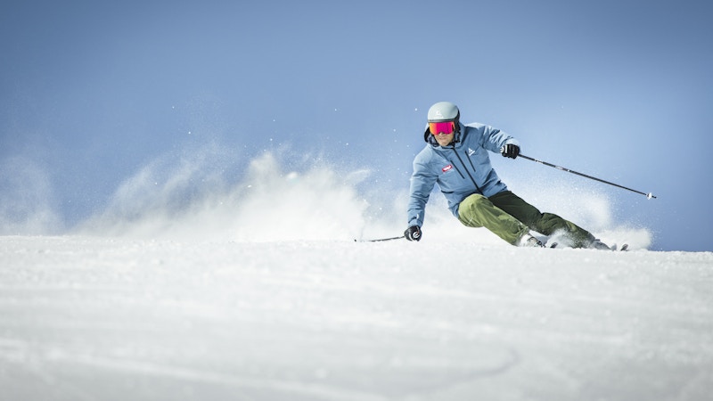 Skifahren lernen; ein fortgeschrittener Skifahrer macht einen Schwung auf der Piste; Schöffel