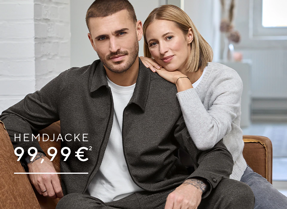 Ein Model trägt eine dunkelgraue Hemdjacke über weißem T-Shirt.
