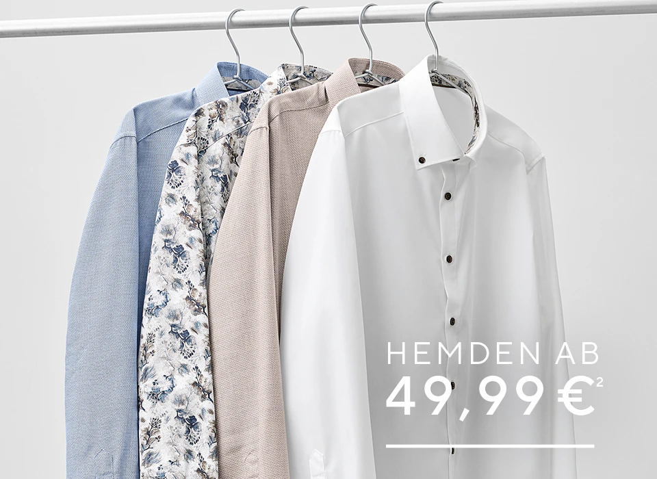 Businesshemden in Weiß, Beige, Blau und mit floralem Muster hängen auf Bügeln.
