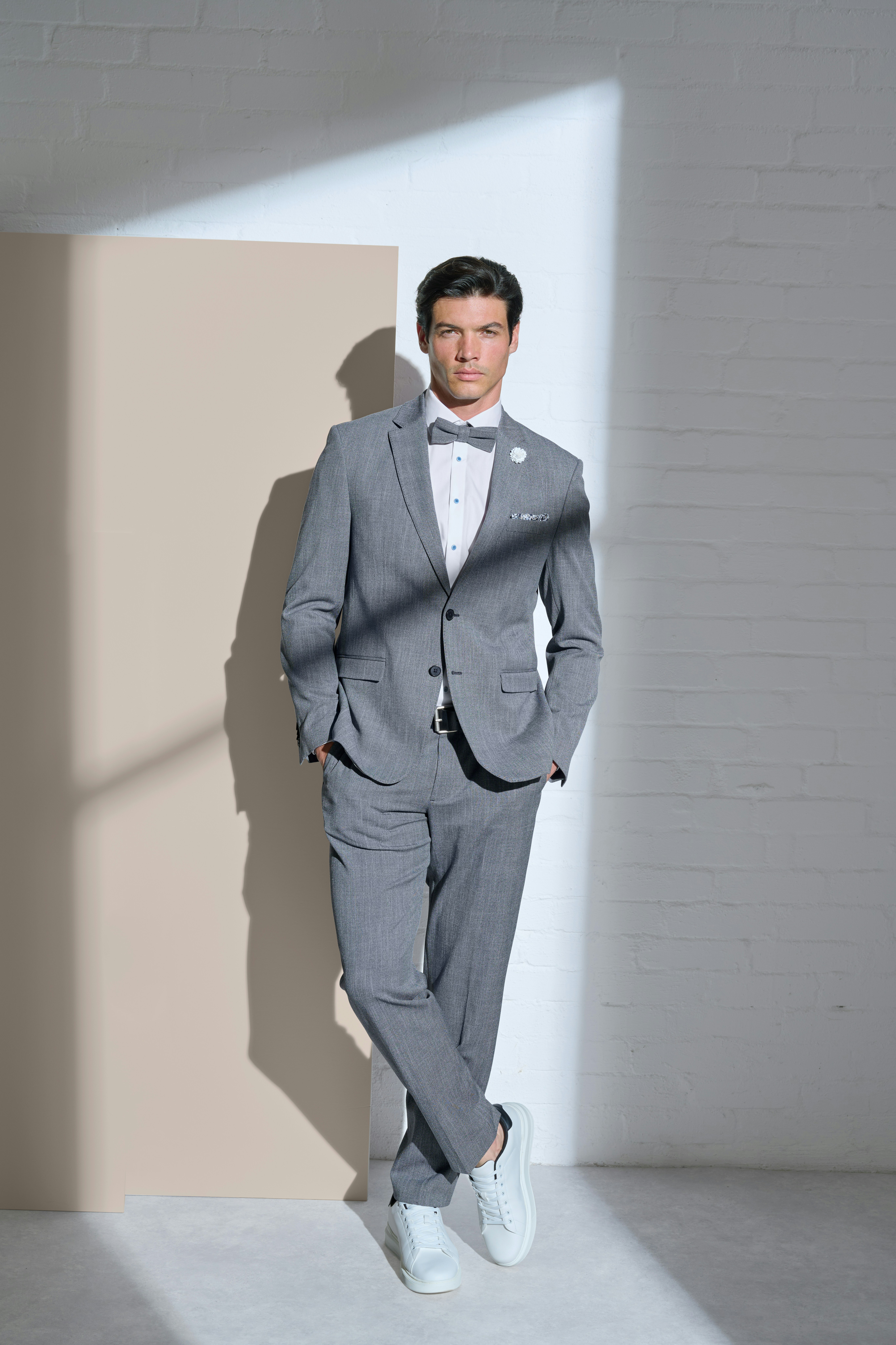 Junger Mann posiert mit einem dunkelgrauen Sakko und einer Fliege von VENTI