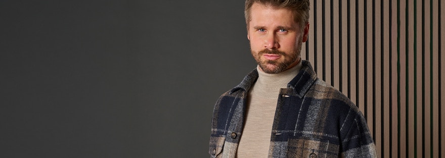 Thore Schölermann mit einer karierten Hemdjacke und einem beigen Rollkragenpullver von VENTI
