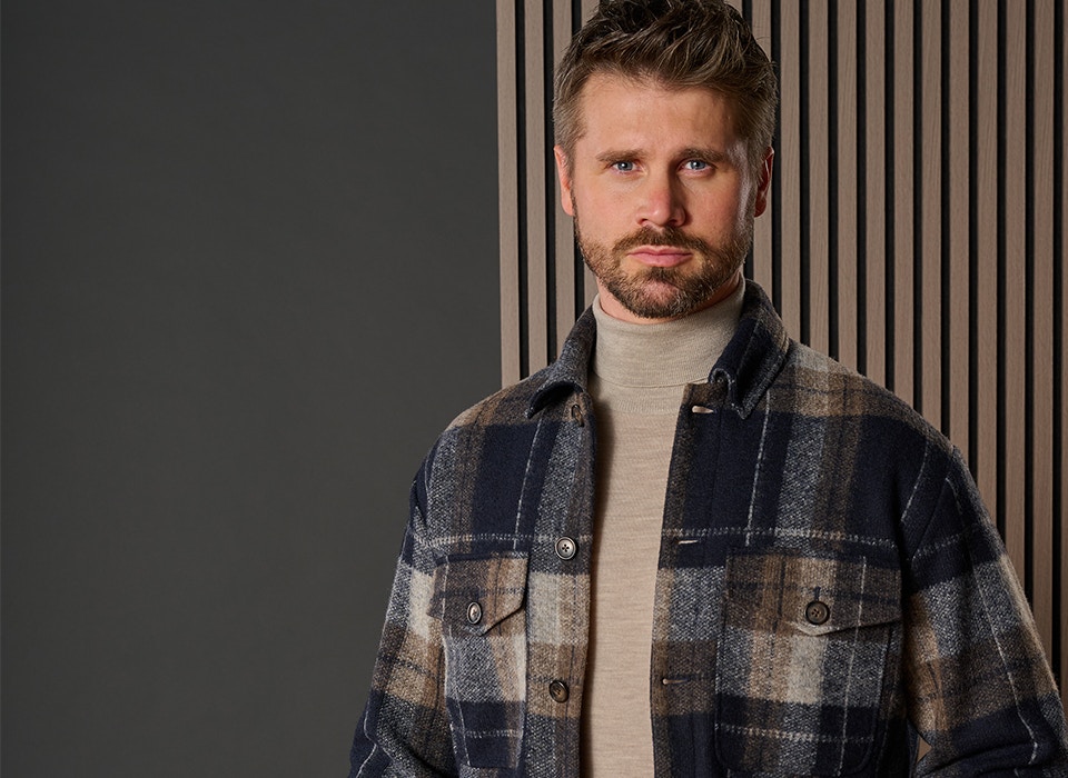 Thore Schölermann posiert mit einer blau karierten Hemdjacke von VENTI