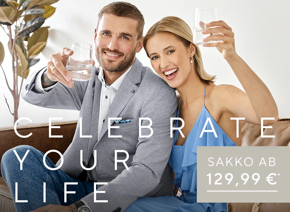 Mann in hellem Sakko und weißem Hemd sitzt neben Frau in blauem ärmellosen Oberteil, beide halten Trinkgläser in der Hand