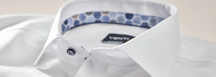 Detailaufnahme eines weißen Hemdes mit klassischem Kragen, sichtbaren Knöpfen und gemustertem Innenkragen in Blau- und Beigetönen mit VENTI-Label