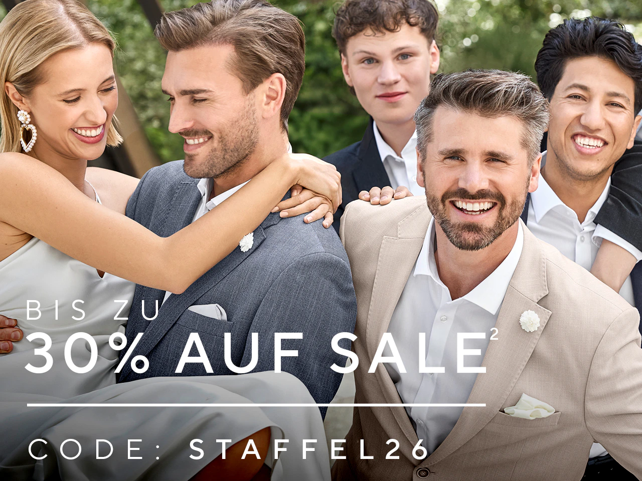 Gruppe von Personen in eleganter Kleidung, mehrere Männer in Anzügen und eine Frau in hellem Kleid, lachend im Außenbereich