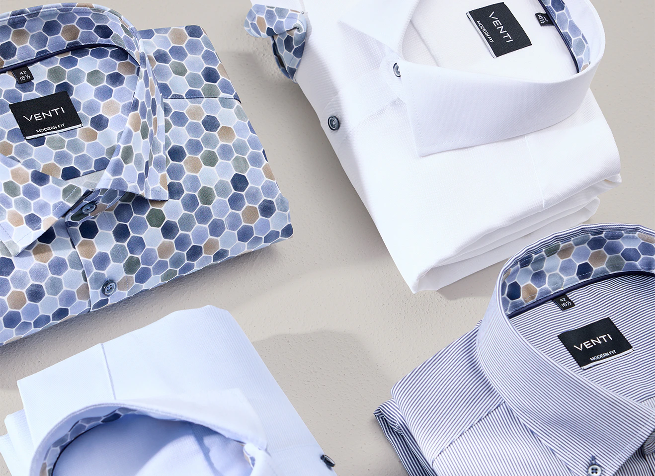 Businesshemden in weiß und blau von VENTI liegen auf dem Tisch